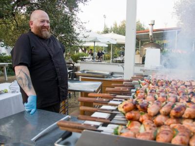 Chef grille des brochettes en plein air.