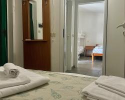 Camera d'albergo semplice con letto, specchio e vista su un'altra stanza.