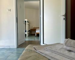 Camera con letto a castello, asciugamani piegati sul letto, pavimento piastrellato.