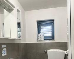 Bagno con lavabo, bidet, WC, specchio e finestra; acqua non potabile indicata.